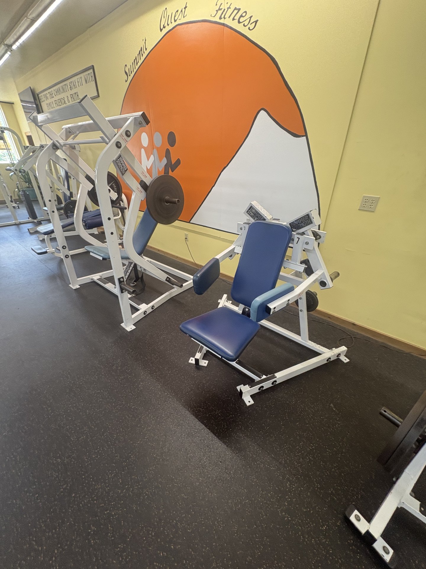 Strength machine in front of the Summit Quest Fitness mural